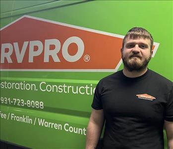 SERVPRO employee smiling in front of a green background