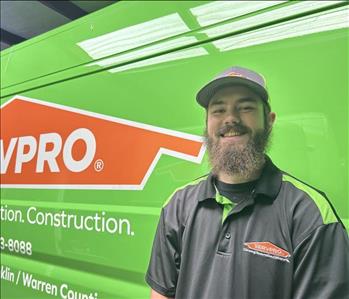 SERVPRO employee smiling in front of a green background