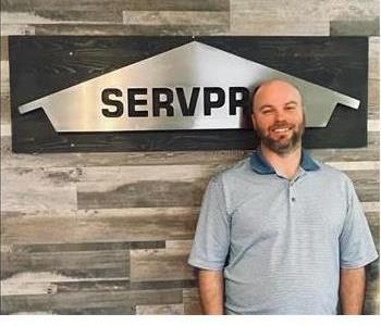 Man Wearing Polo Shirt in front of Servpro sign